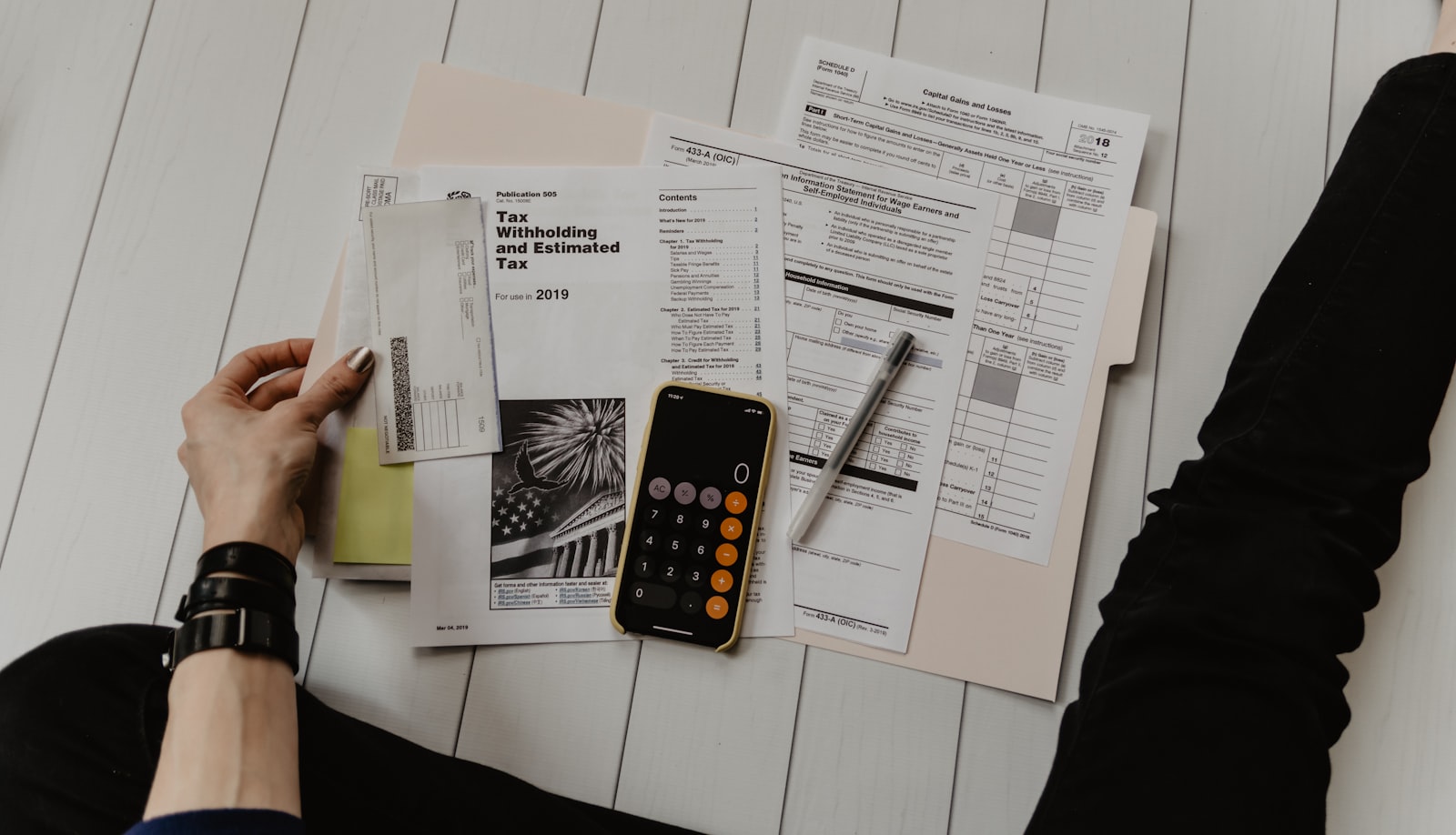 Calculator and household bills used to plan a 90-day savings gap